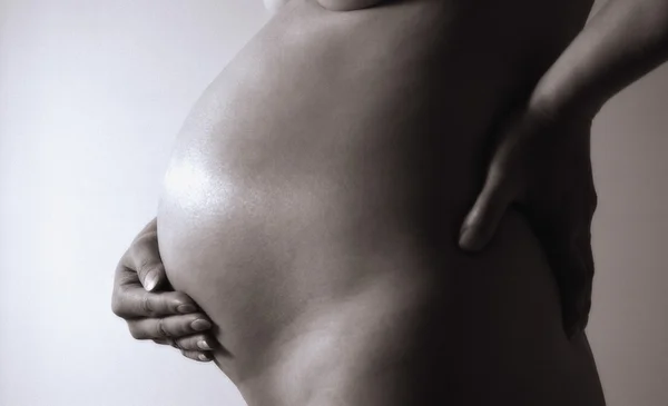 Femme enceinte nue avec la main sur le ventre — Photo