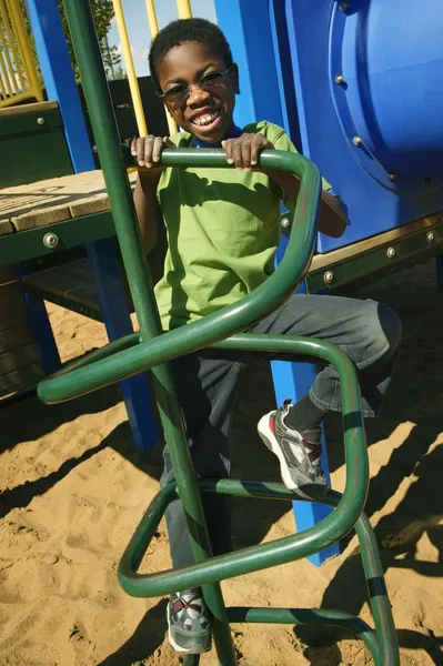 Mladý chlapec, lezení na vybavení dětských hřišť — Stock fotografie