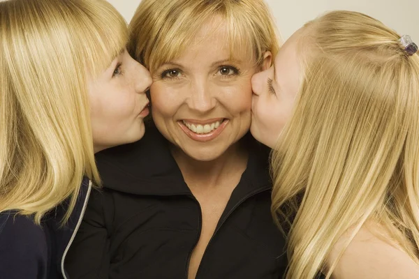 Töchter küssen ihre Mutter auf die Wange — Stockfoto