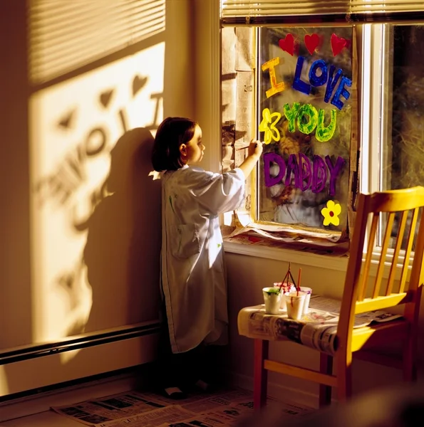 绘画 '我爱你爸爸' 在窗口上的小女孩 — 图库照片