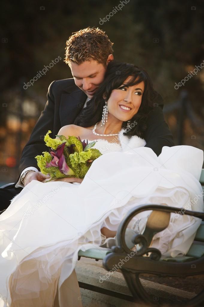 Newly Married Couple Sitting On A Bench