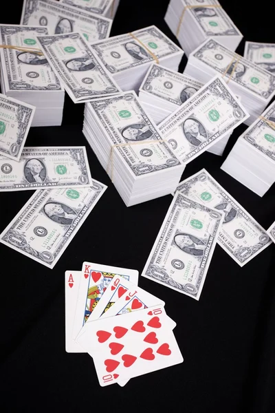 Piles of money and playing cards — Stock Photo, Image