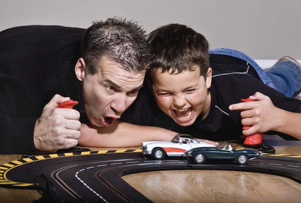 Father And Son Playing With Race Cars