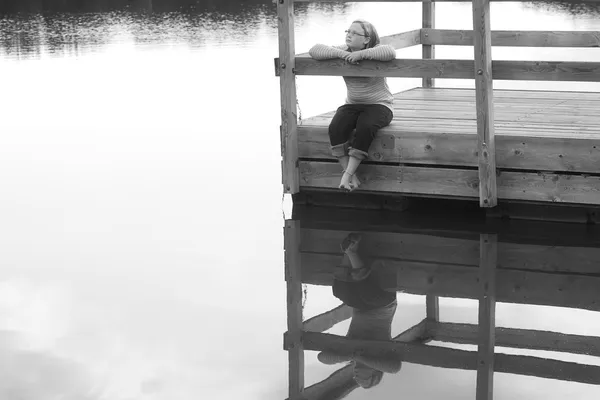 Chica sentada en un muelle — Foto de Stock