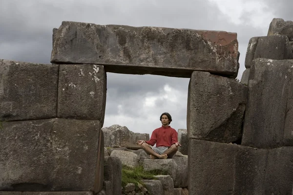 Un joven medita en antiguas ruinas incas en las afueras de Cuzco, Perú —  Fotos de Stock