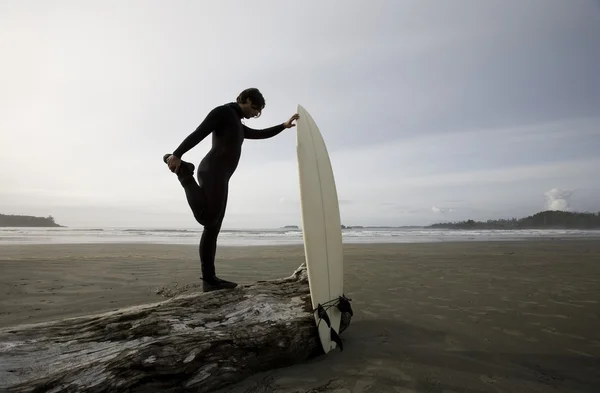 Surfista se alongando na praia — Fotografia de Stock