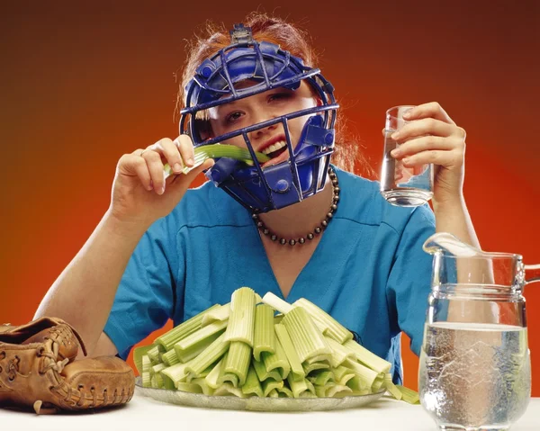 女人穿着吃芹菜的体育器材 — 图库照片