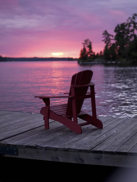 湖的树林，安大略省，加拿大。湖边的码头上的空帆布躺椅。 — 图库照片