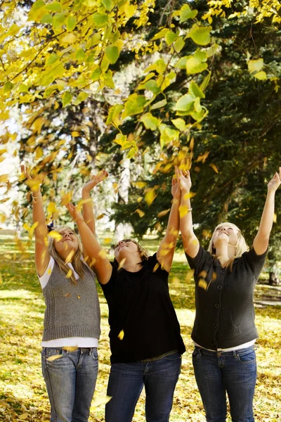 Girls Throwing Leaves In The Air — Stock Photo, Image