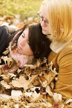 sonbahar yaprakları içinde oturan iki kadın