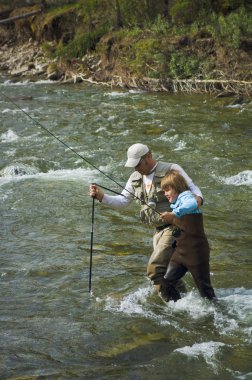 Baba ve oğul bir dağ sinek Balıkçılık nehir geçiş