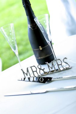 Chrome 'mr & Mrs' Sign Next To Champagne And Cake Server clipart