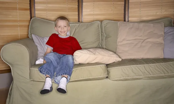 Chlapec seděl na gauči — Stock fotografie