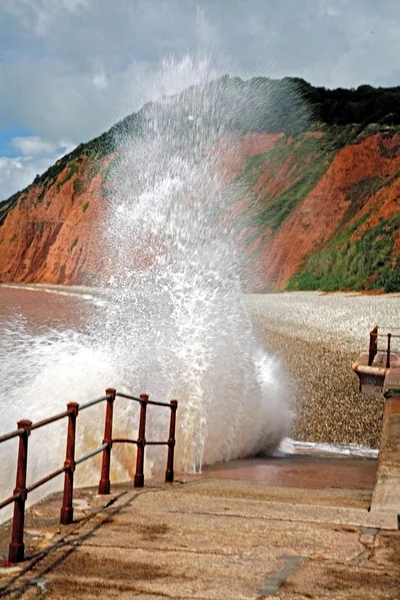 Devon, Anglia, Wielka Brytania. wody morza oprysków przeciwko plaży chodnik — Zdjęcie stockowe