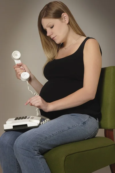 En gravid kvinna med hjälp av telefonen — Stockfoto