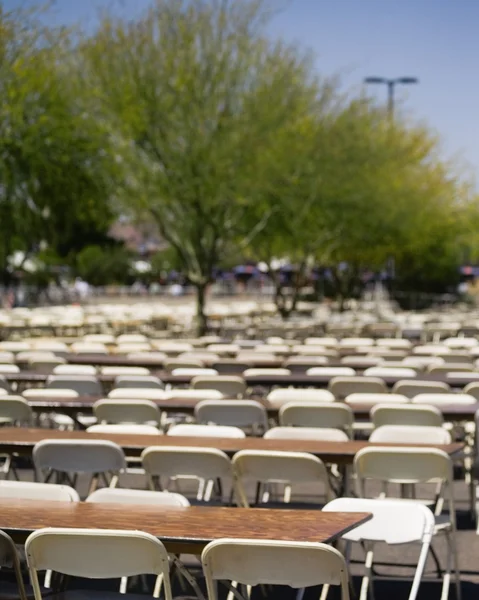 Velké množství prázdných židlí a stolů sedí venku — Stock fotografie