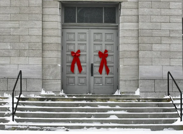红色蝴蝶结的灰色建筑门上 — 图库照片