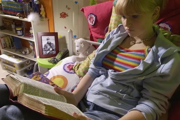 Chica leyendo la Biblia en el dormitorio —  Fotos de Stock