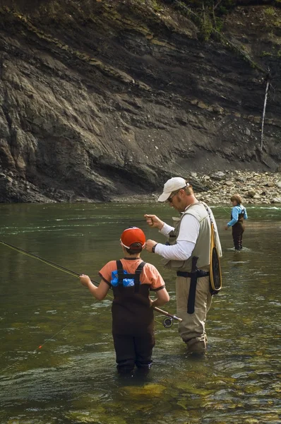 Vader en zonen vliegvissen in berg rivier — Stockfoto