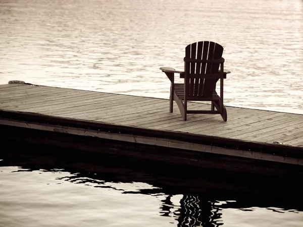 See der Wälder, Ontario, Kanada. Leere Liegestühle auf einem Steg neben einem See — Stockfoto