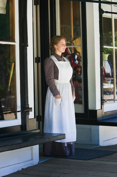 Jeune femme debout à la porte du magasin — Photo