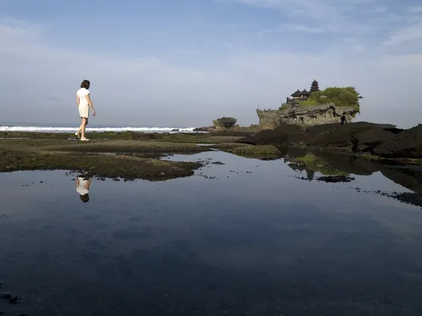 Tanah Lot Sea Temple, Bali, Indonesia. Donna che cammina lungo la riva — Foto Stock