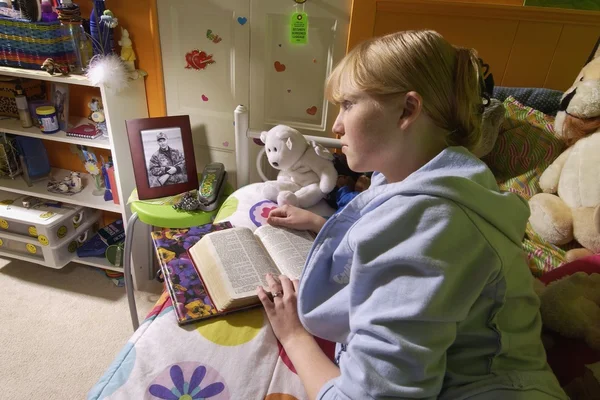 在卧室里的女孩阅读圣经 — 图库照片