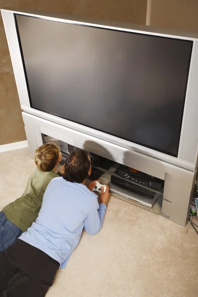 Vader en zoon met behulp van tv spelbesturingen — Stockfoto