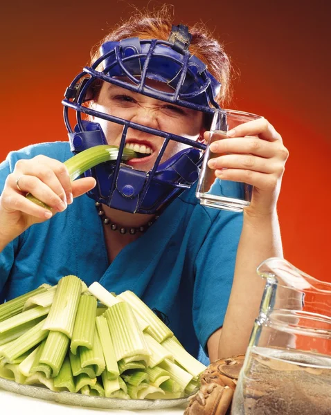 Žena v sportovní potřeby jíst celer — Stock fotografie