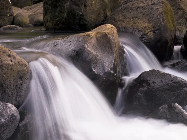 Água fluindo sobre rochas, Napali Coast State Park, Kauai, Havaí — Fotografia de Stock