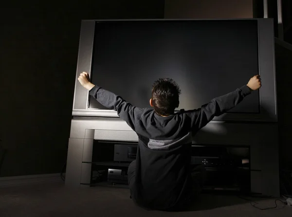 Niño sentado frente a la televisión —  Fotos de Stock