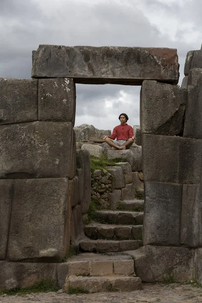 Молодой человек медитирует в древних руинах инков за пределами Куско, Перу — стоковое фото