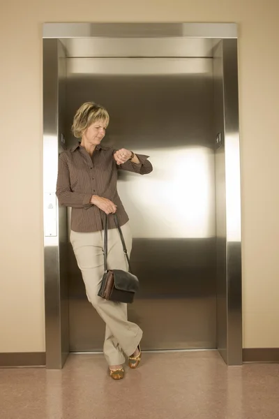 Mulher à espera de um elevador — Fotografia de Stock