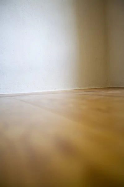 Prázdná místnost s dřevěnou podlahou a bílými stěnami — Stock fotografie