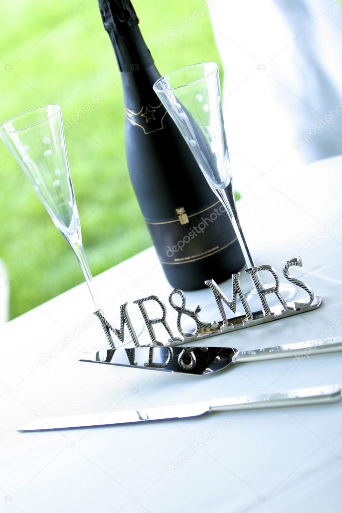 Chrome 'mr & Mrs' Sign Next To Champagne And Cake Server