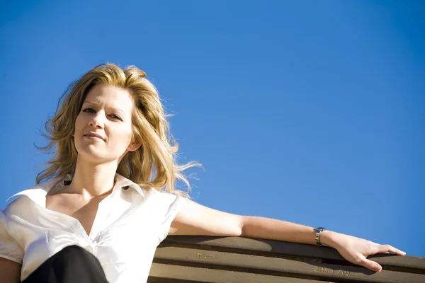 Vrouw zittend op een bank — Stockfoto