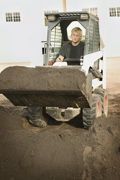 Mann betätigt kleinen Bagger — Stockfoto