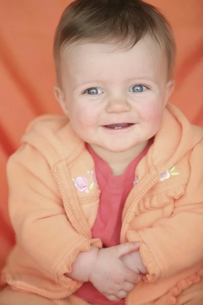 Meisje van de baby in oranje jas — Stockfoto