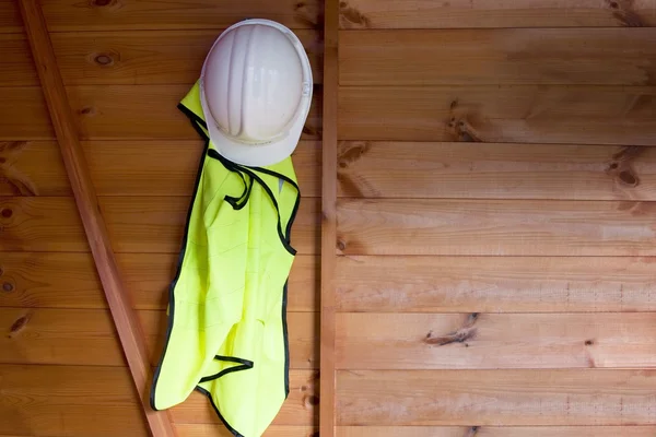 Reflecterend vest en veiligheidshelm opknoping op de muur — Stockfoto