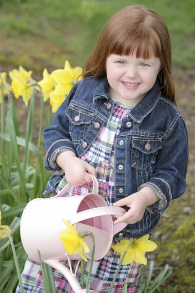 Pequena menina regando flores — Fotografia de Stock