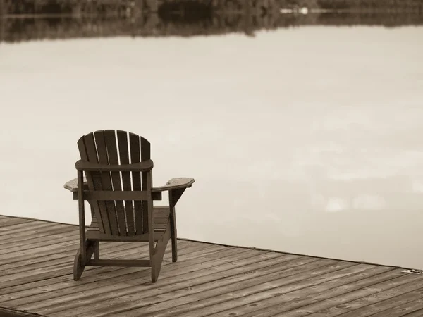 See der Wälder, Ontario, Kanada. Leere Liegestühle auf einem Steg neben einem See — Stockfoto