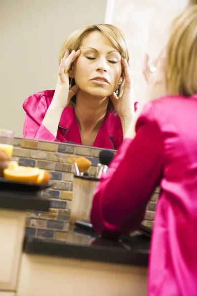 Vrouw masseren haar hoofd in spiegel — Stockfoto