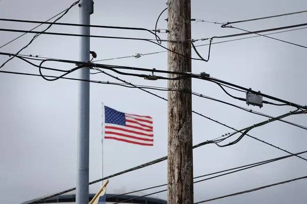 Amerikai zászló mögött telefon vezetékeket és elektromos vezetékek Stock Kép