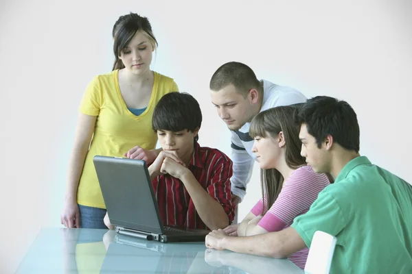 Grupo de adolescentes reunidos em torno de um computador portátil — Fotografia de Stock