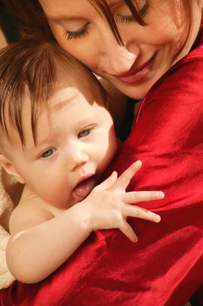 Мать держит ребенка в руках после купания — стоковое фото