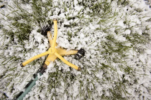 Arroseur sur neige et herbe. Edmonton, Alberta, Canada — Photo