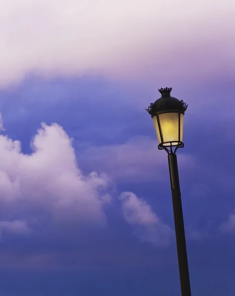 Lámpara iluminada contra un cielo nublado —  Fotos de Stock