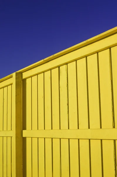 Clôture jaune vif avec ciel bleu et neige — Photo