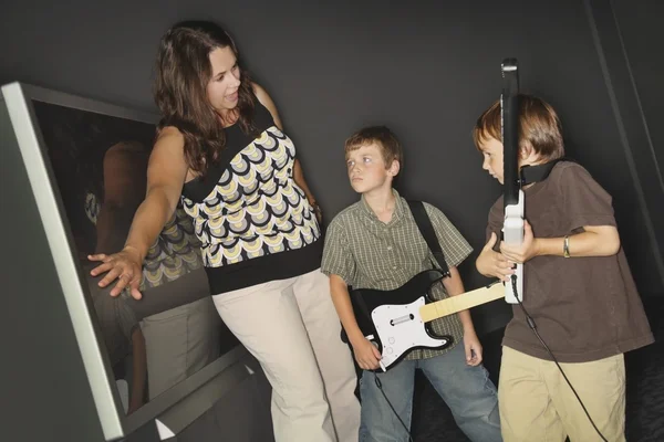 Mãe dizendo a seus filhos para parar de jogar seu jogo de música — Fotografia de Stock