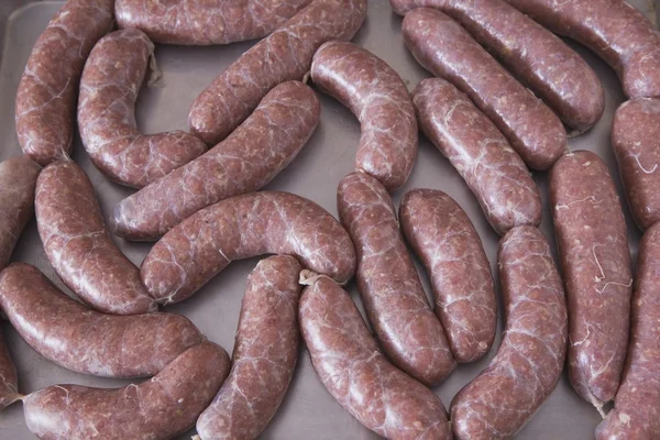 Saucisse crue sur une plaque à pâtisserie — Photo